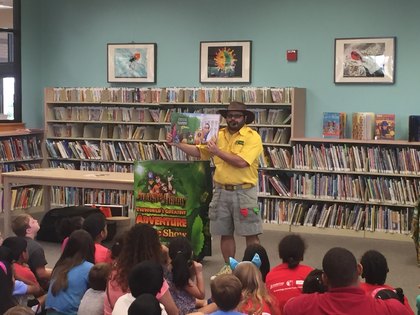 Jimmy Vee reading to children in a library